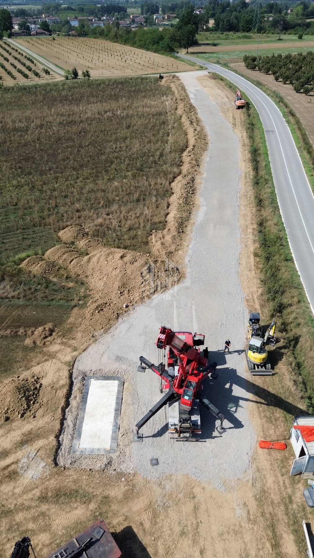 Campo fotovoltaico — strada di accesso e cabina MT — Autogru in piazzamento per il sollevamento della cabina