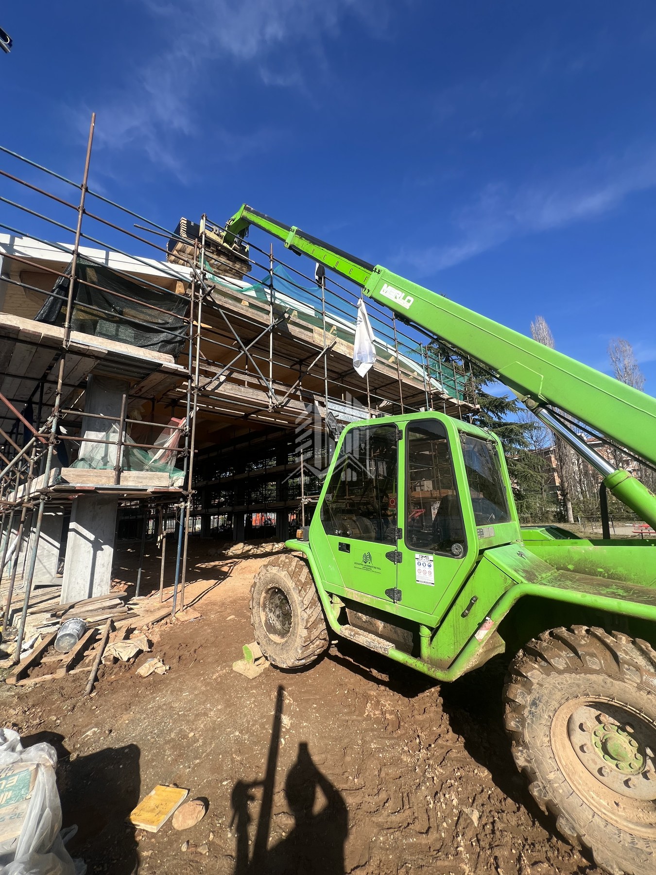 Carrello elevatore telescopico Merlo con marchio aziendale in cantiere