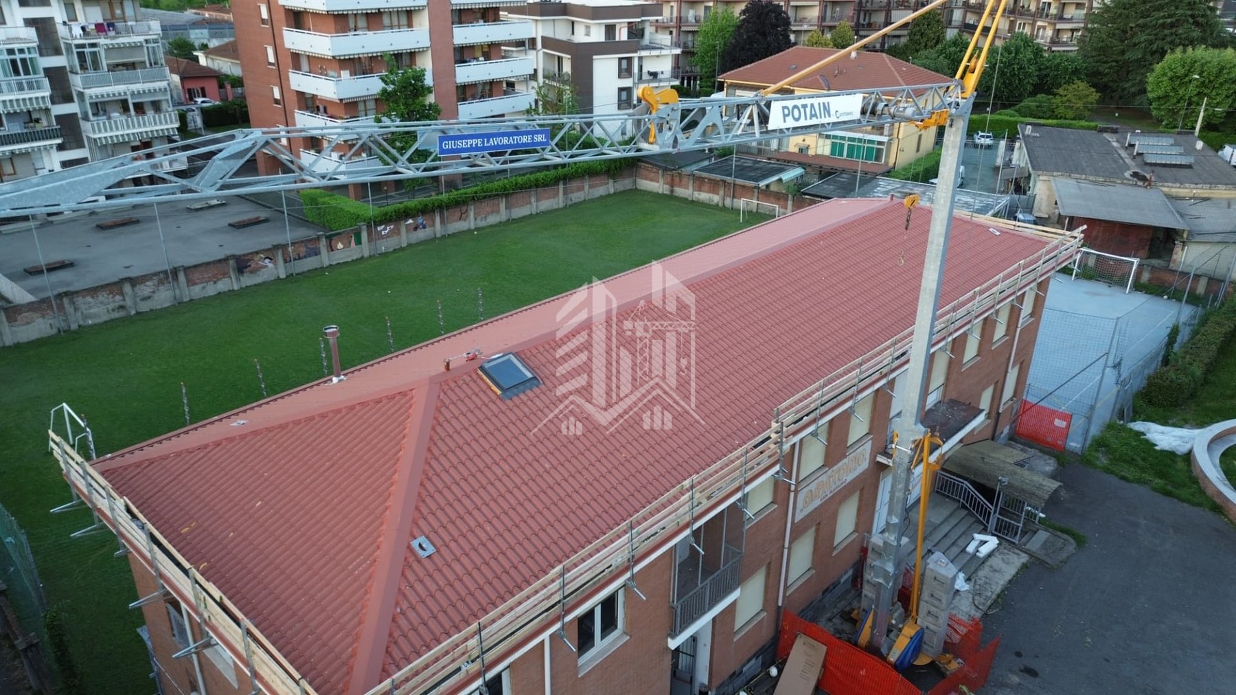 Gru a torre con banner Giuseppe Lavoratore SRL su cantiere di copertura in tegole