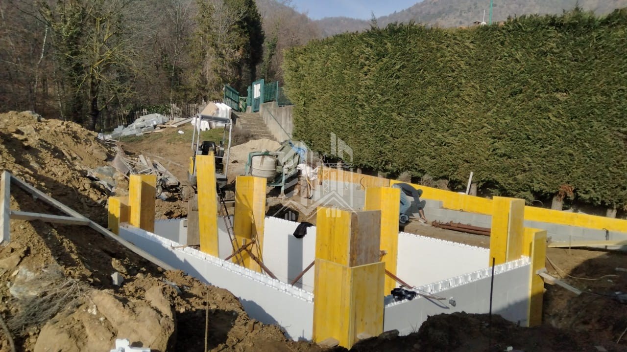 Piscina con terrazzamenti in zona montana — Posa dei blocchi e casseri per i getti della vasca